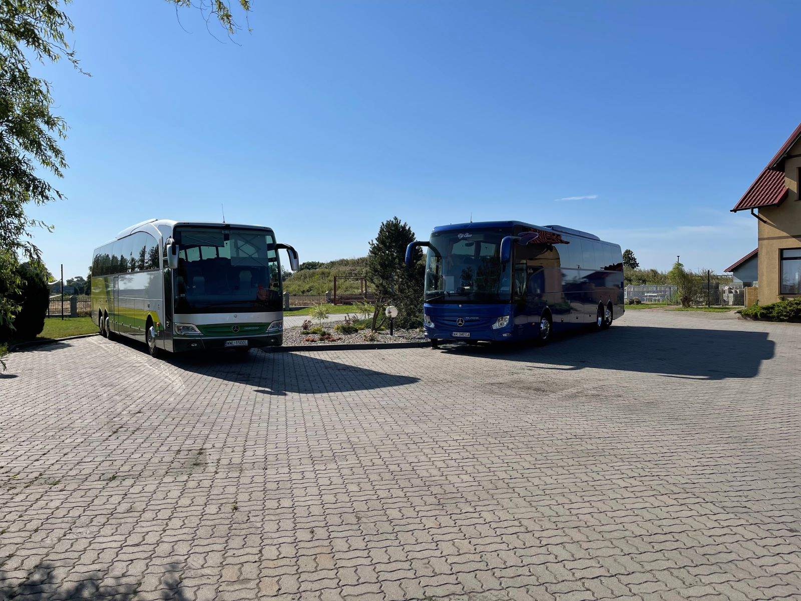 Dwa autokary tyrystyczne na parkingu oczekujące na grupę seniorów nad morzem